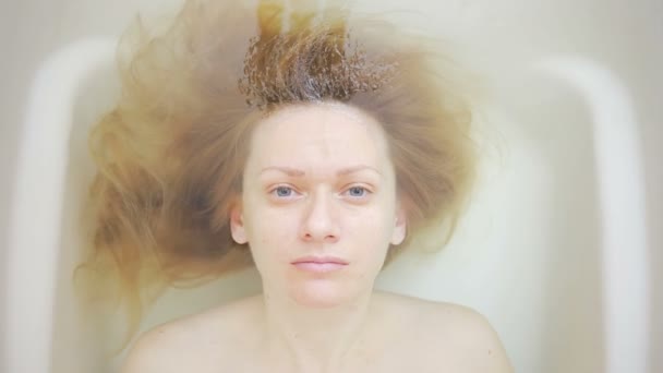 Primer plano de una mujer sin maquillaje, acostada en el baño . — Vídeos de Stock