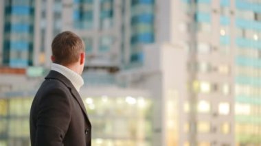 şık ceket adam, yaşayan gökdelenler arka plan üzerinde yürüme bir