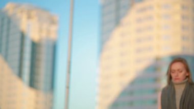 gökdelenler arka plan üzerinde modern bir şehir kız pembe bir ceket yürür