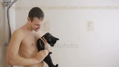 bir adam siyah bir kedi ile duş alıyor. yakın çekim