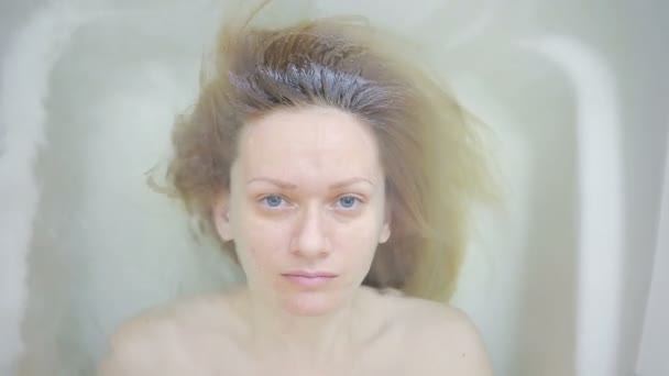 Крупный план женщины без макияжа, лежащей в ванной . — стоковое видео