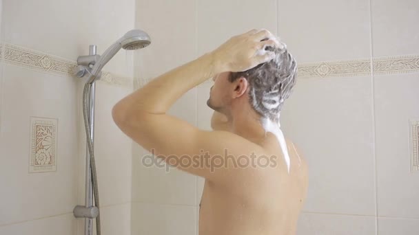 Man tvätta håret med schampo i duschen. badrum. — Stockvideo