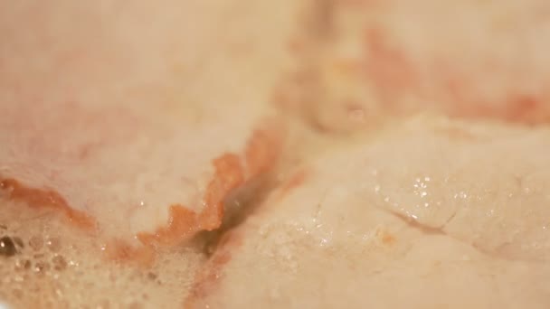 Τηγανίζουμε το κρέας της μπριζόλας. κινηματογράφηση σε πρώτο πλάνο. χοιρινό κρέας σε ένα τηγάνι — Αρχείο Βίντεο