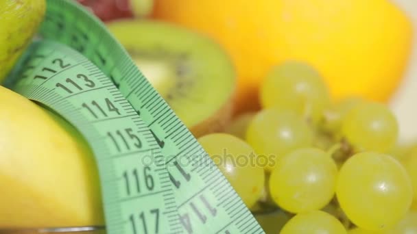 Frutas y cinta métrica de cerca. El concepto de dieta — Vídeos de Stock