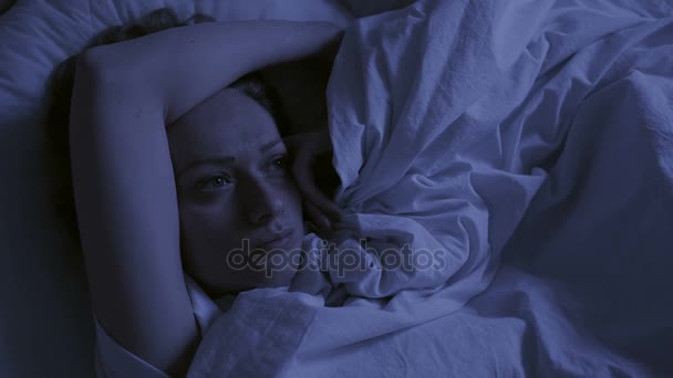 Koncept nespavost. Žena v posteli v noci nemůže spát — Stock video