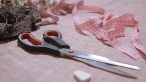 Closeup acessórios de costura. tesoura, pano, fita métrica, fita adesiva — Vídeo de Stock