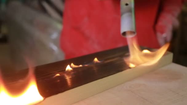 Deska s hořící oheň plynového hořáku. sostarivayut strom. Barva wenge — Stock video