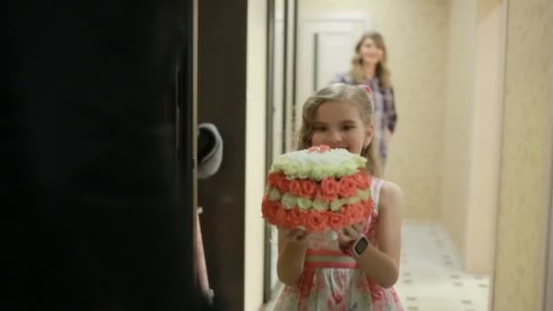 Petite fille présentée avec un délicat bouquet de roses roses et blanches — Video