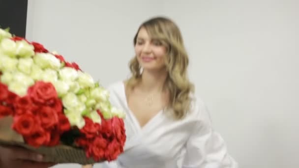 Un hombre dando flores a una joven. un gran ramo de rosas rojas y blancas — Vídeos de Stock