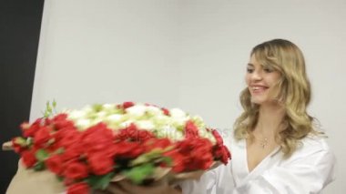 Genç bir kıza çiçek veren adam. büyük bir kırmızı ve beyaz gül buketi