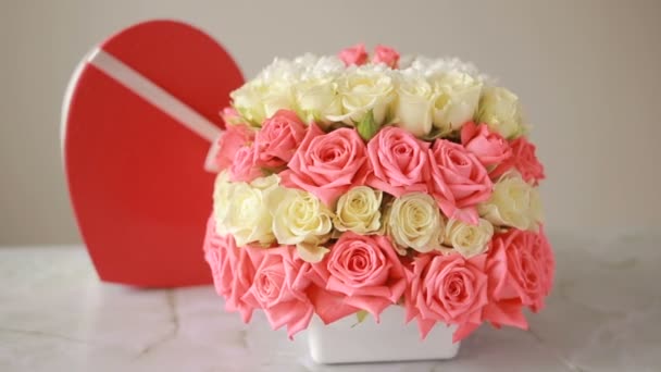 Λεπτό μπουκέτο με ροζ και λευκά τριαντάφυλλα. κουτί με ένα δώρο με τη μορφή της καρδιάς — Αρχείο Βίντεο