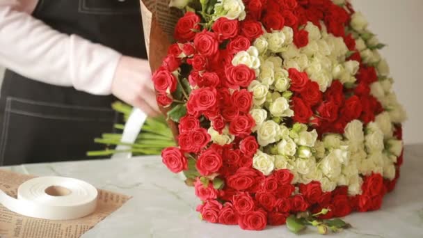 Heldere kleurrijke boeket van rode en witte rozen, bloemist vrouw verzamelt een boeket — Stockvideo