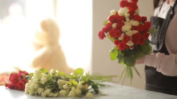 Heldere kleurrijke boeket van rode en witte rozen, bloemist vrouw verzamelt een boeket — Stockvideo