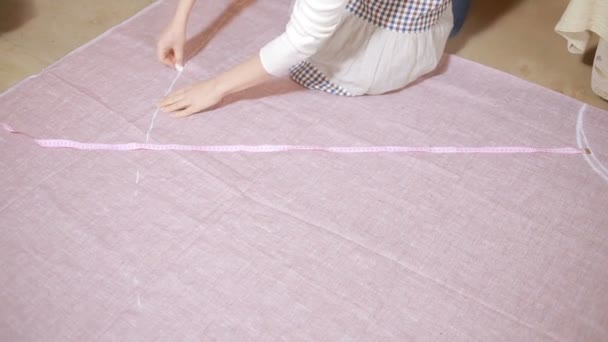 Hands of a seamstress. Seamstress tape measure applies to the fabric. — Stock Video