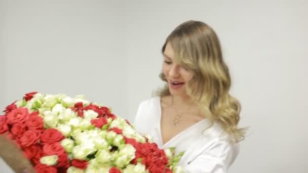 Un hombre dando flores a una joven. un gran ramo de rosas rojas y blancas — Vídeos de Stock