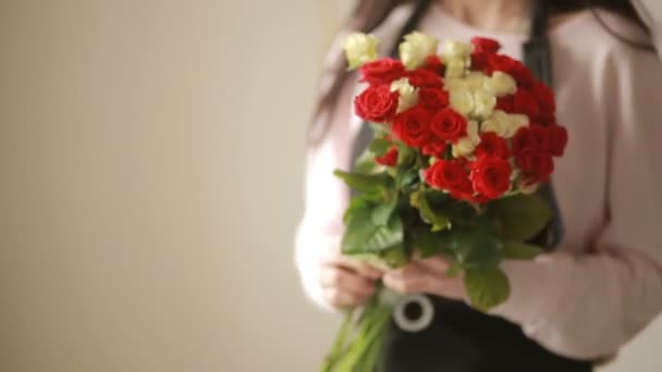 Heldere kleurrijke boeket van rode en witte rozen, bloemist vrouw verzamelt een boeket — Stockvideo