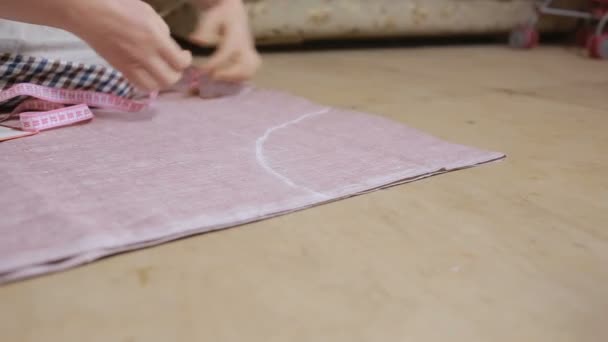 Hands of a seamstress. Seamstress tape measure applies to the fabric. — Stock Video