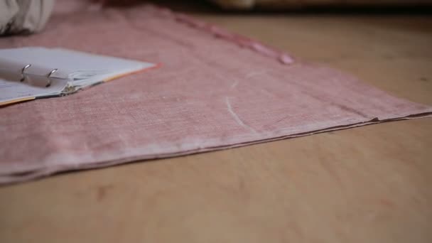 Mãos de uma costureira. fita métrica seamstress aplica-se ao tecido . — Vídeo de Stock