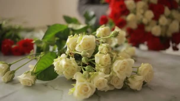 Světlé barevné kytice z červených a bílých růží, květinářství žena shromažďuje kytice — Stock video