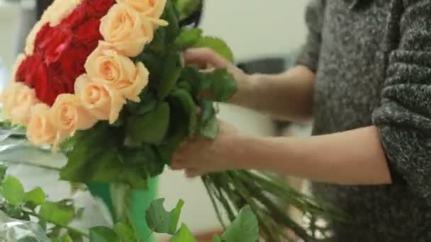 Ljusa färgglada bukett röda och persika rosor, florist kvinna samlar en bukett — Stockvideo