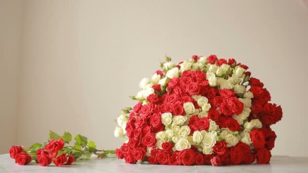 Bouquet coloré lumineux de roses rouges et blanches, fleuriste femme rassemble un bouquet — Video