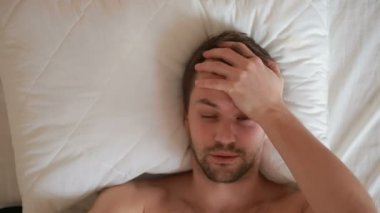 bir adam bir ateşle evde yatakta yatıyor