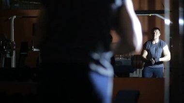 spor salonunda bir ayna önünde poz vücut geliştiricisi. poz