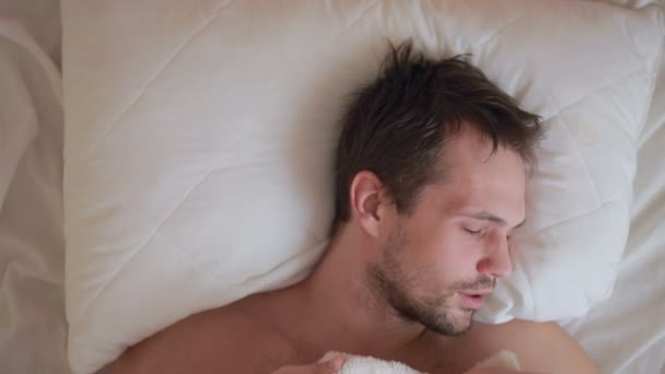 Un hombre con fiebre está acostado en la cama en casa — Vídeo de stock