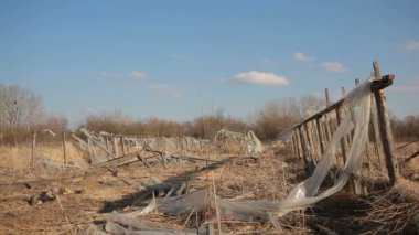 Arka plan beyaz bulutlar ve mavi gökyüzü üzerinde terk edilmiş sera.