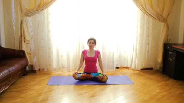Mujer joven haciendo ejercicios de estiramiento en casa — Vídeos de Stock