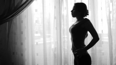 Evde esneme egzersizleri yapan genç bir kadın.