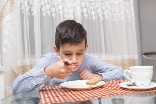 Niño comiendo sopa en la mesa de la cocina — Foto de Stock