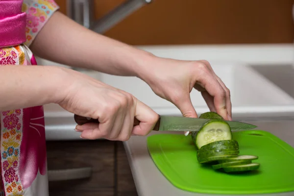 Fechar as mãos femininas cortando pepino — Fotografia de Stock