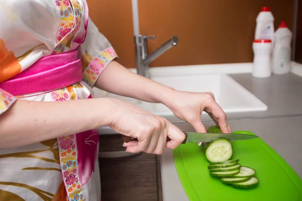 Fechar as mãos femininas cortando pepino — Fotografia de Stock