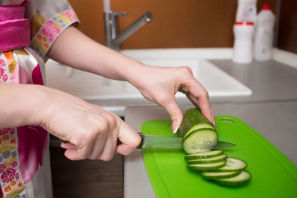 Fechar as mãos femininas cortando pepino — Fotografia de Stock