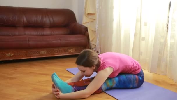 Giovane donna che fa esercizi di stretching a casa — Video Stock