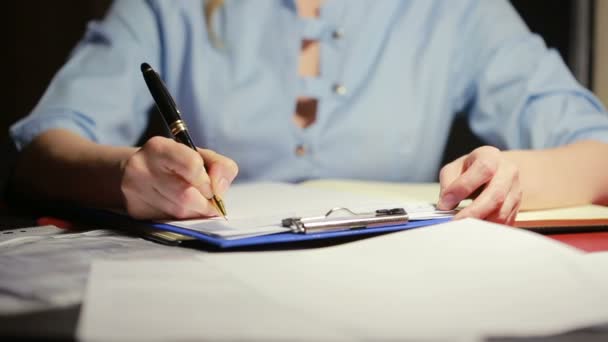 Vrouw arts schrijft een pen met een hals in de documenten — Stockvideo