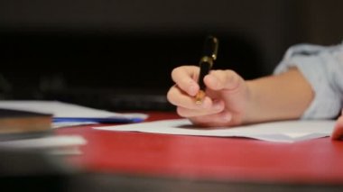 Çocuk el bir kalem kağıt üzerinde yazıyor.