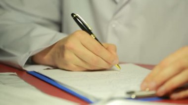 erkek beyaz laboratuar kat yazma kalem belgelerde elinde.