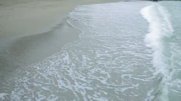 Fille en manteau rose avec un parapluie transparent au bord de la mer pendant une tempête . — Video