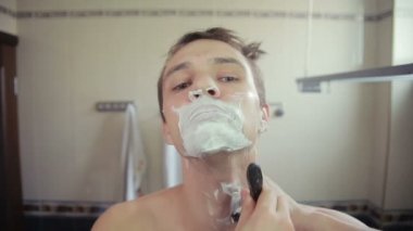 adam banyoda jilet ile onun sakalı tıraş