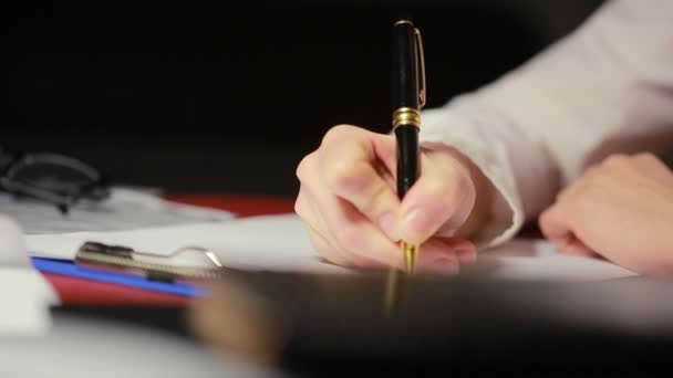 Mano femenina escribe un bolígrafo sobre papel . — Vídeo de stock