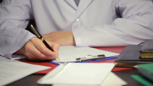 Αρσενική χέρι σε ένα λευκό εργαστήριο παλτό γραφής στυλό στα έγγραφα. — Αρχείο Βίντεο