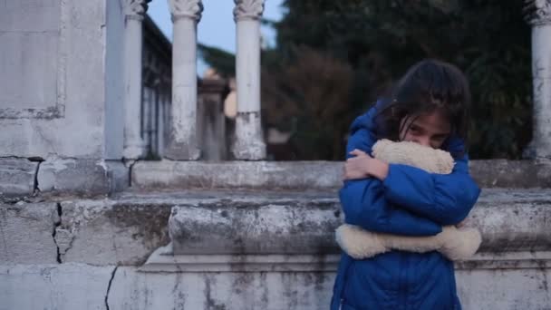 De vluchtelingen van de kinderen tegen de achtergrond van gebombardeerde huizen. oorlog — Stockvideo