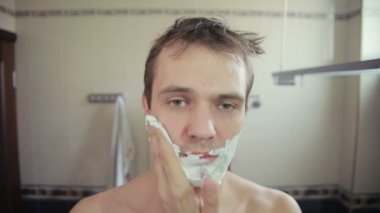 adam banyoda jilet ile onun sakalı tıraş