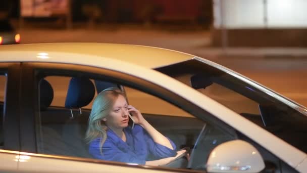 Chica por la noche hablando por teléfono mientras está sentado en el coche — Vídeos de Stock