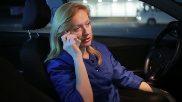 Meisje in de avond praten over de telefoon zittend in de auto — Stockvideo