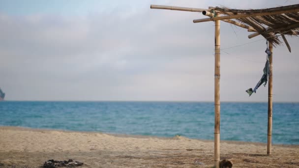 Kollapsade markis av bambu på en övergiven strand. Inte säsongen, ekologi koncept — Stockvideo