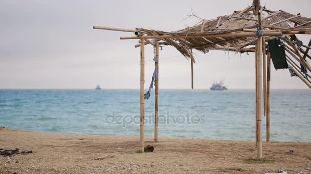 Eingestürzte Markise aus Bambus an einem verlassenen Strand. nicht die Saison, ökologisches Konzept — Stockvideo