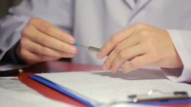 erkek beyaz laboratuar kat yazma kalem belgelerde elinde.